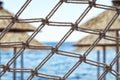 Net fence on a beautiful beach - resort umbrellas, sea and sky i Royalty Free Stock Photo